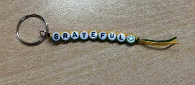 Handmade beaded keyring spelling GRATEFUL with a smiley face