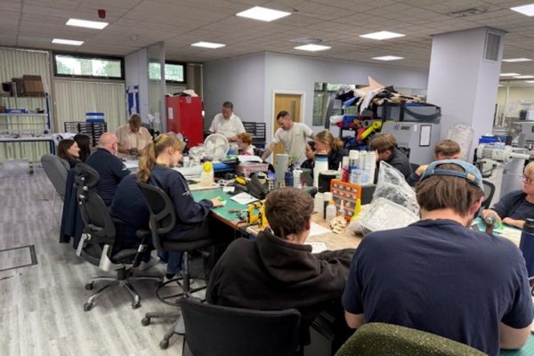 Crispin team members at their workbenches taking part in the Monday Bingo game