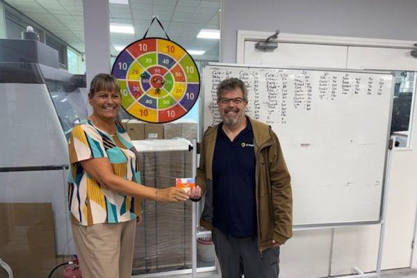 A colleague receiving a prize in front of the Sticky Balls target and scoreboard